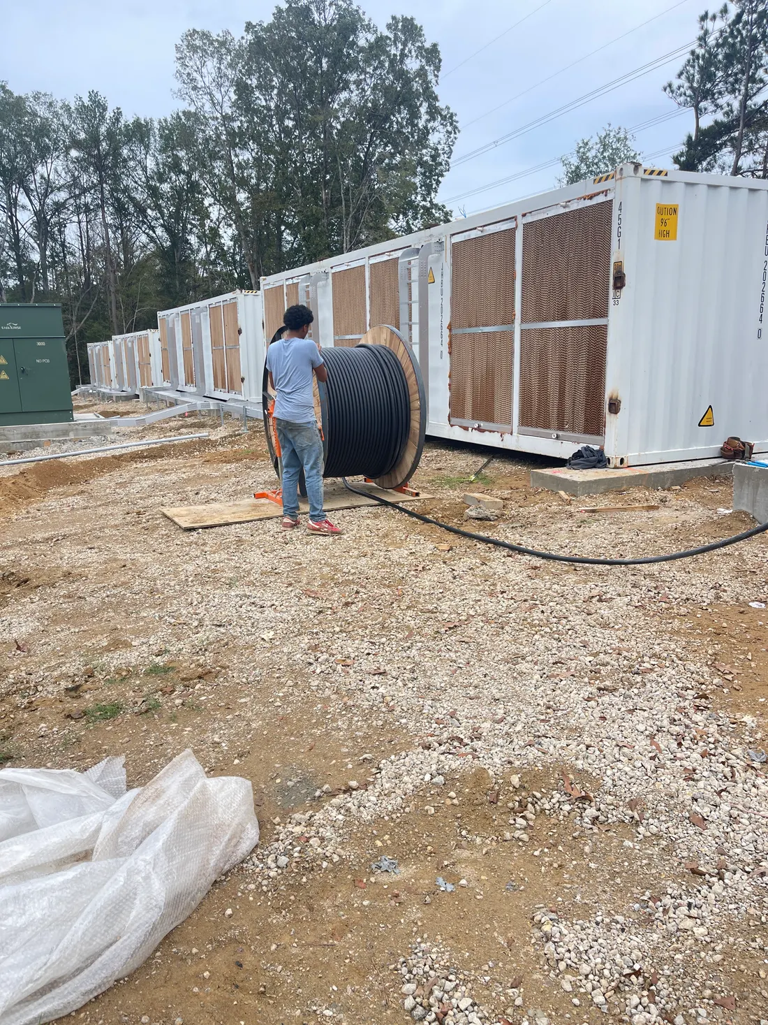 Field crew handling cable spool during site work and logistics coordination