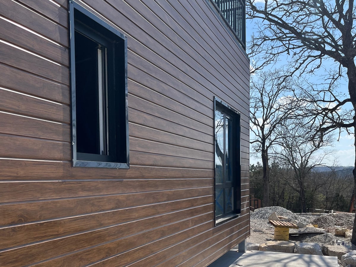 Reference prefab home exterior cladding, openings, and nearby site condition for finish and scope review