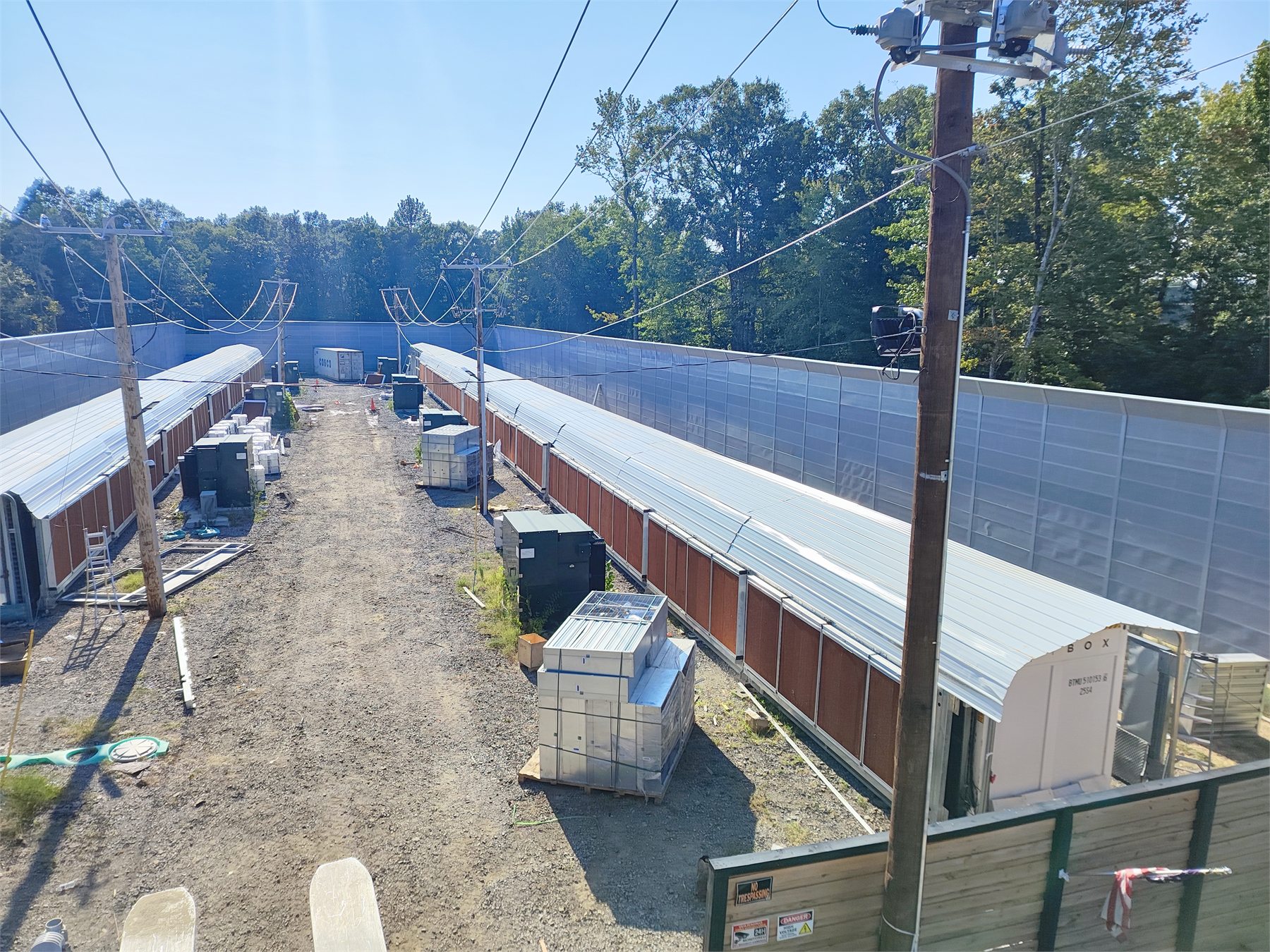 Data center site corridor with access lanes, power lines, equipment areas, and field work context
