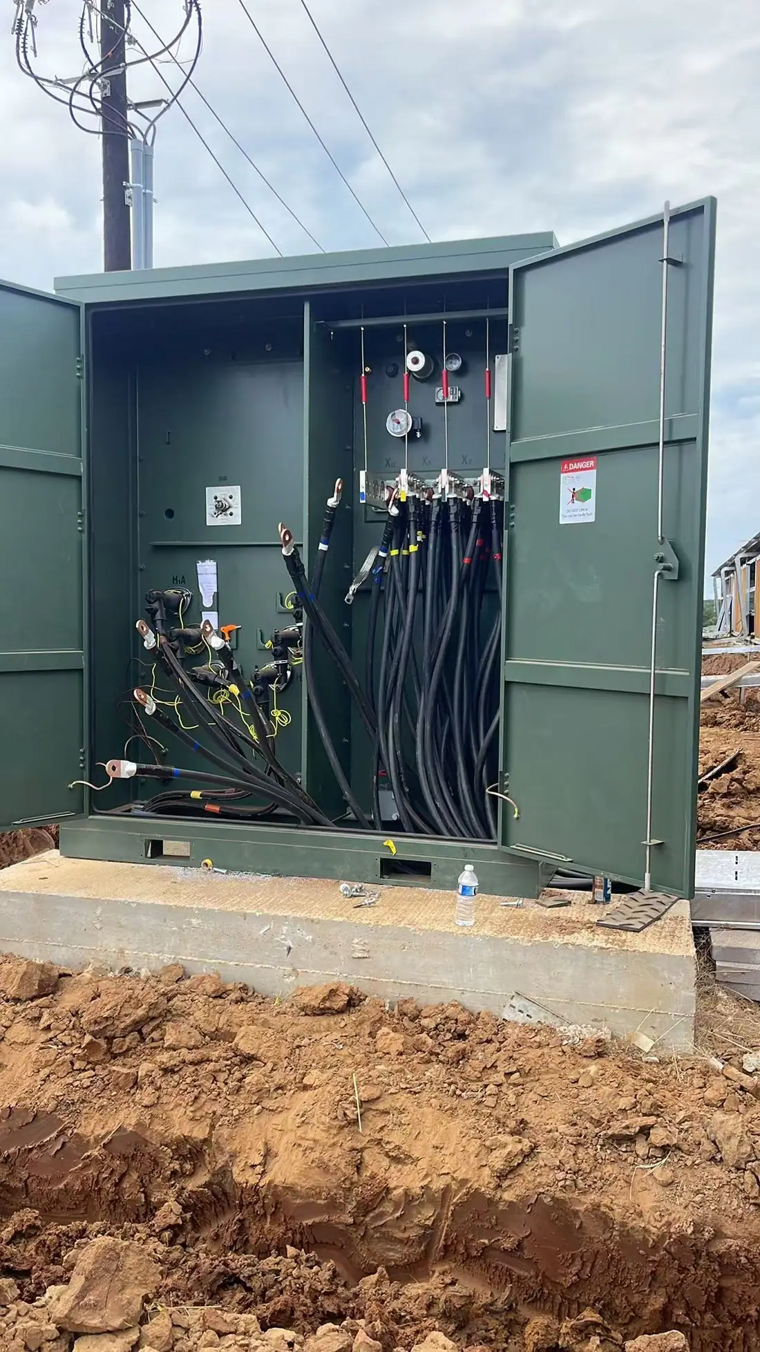 Open transformer cabinet showing field coordination and power-distribution work