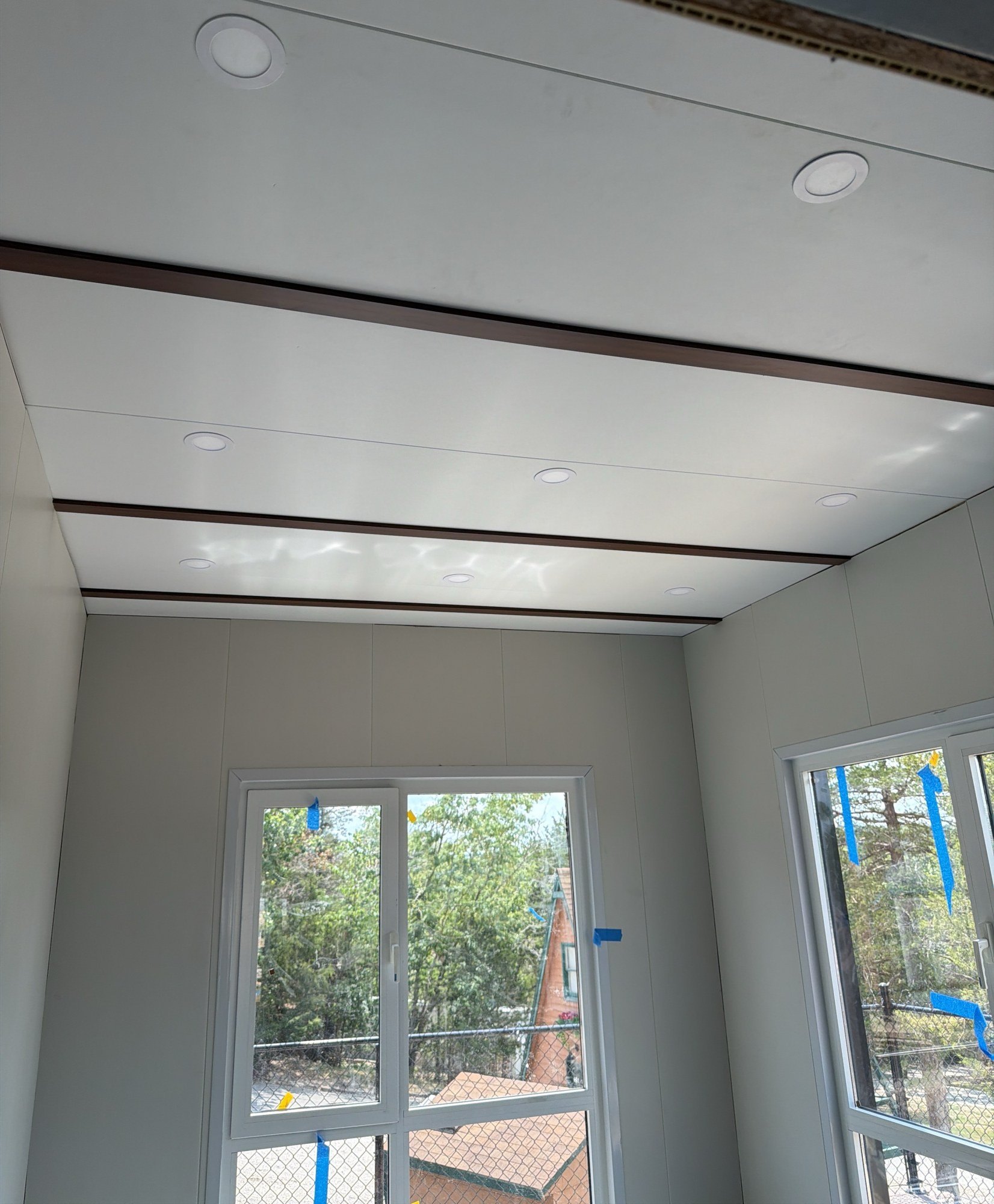 Finished room with a lined ceiling, recessed downlights and glazed doors to the outside, 29 July 2026