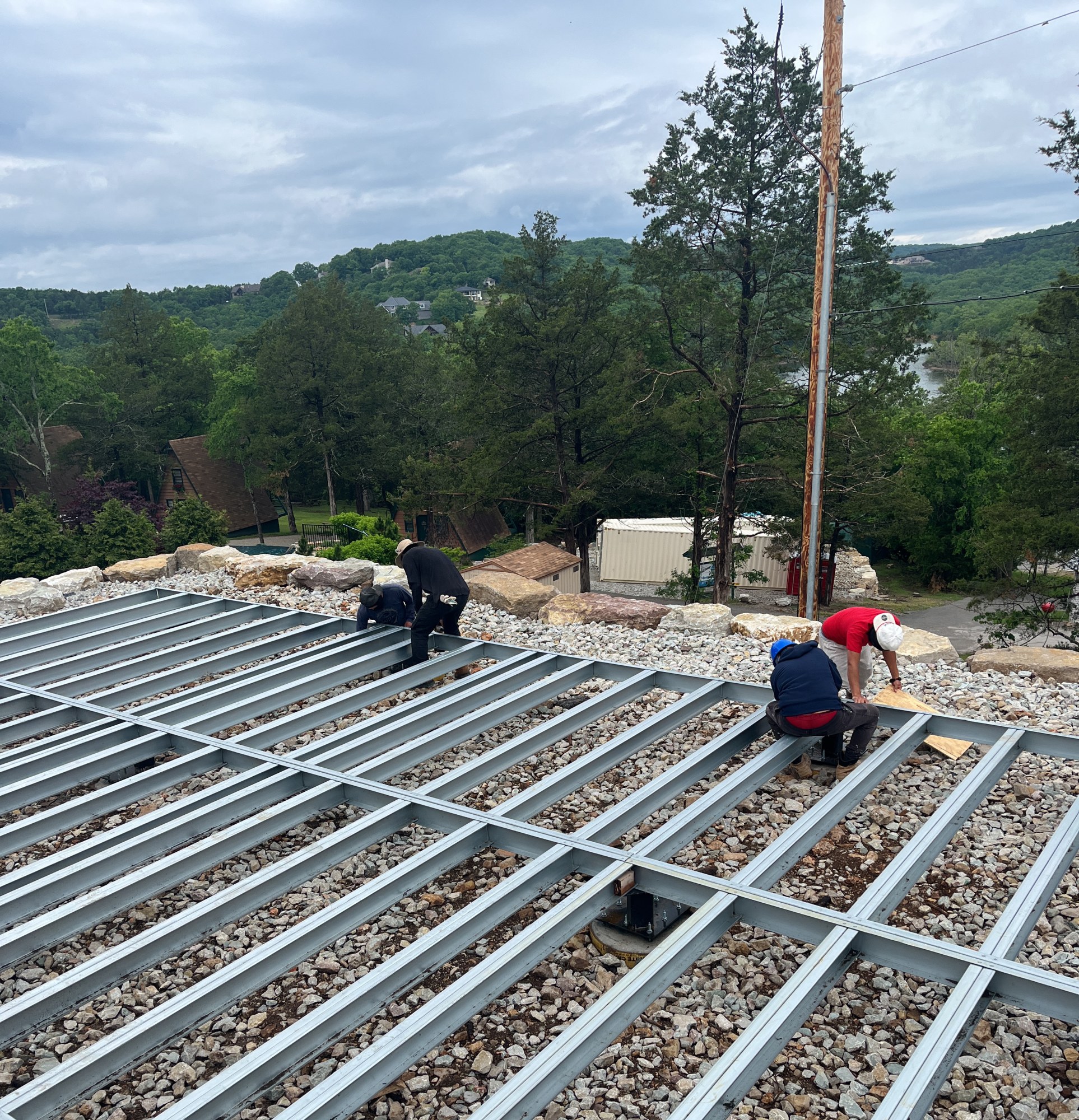 Four crew members fastening the steel floor frame on site, 5 May 2026