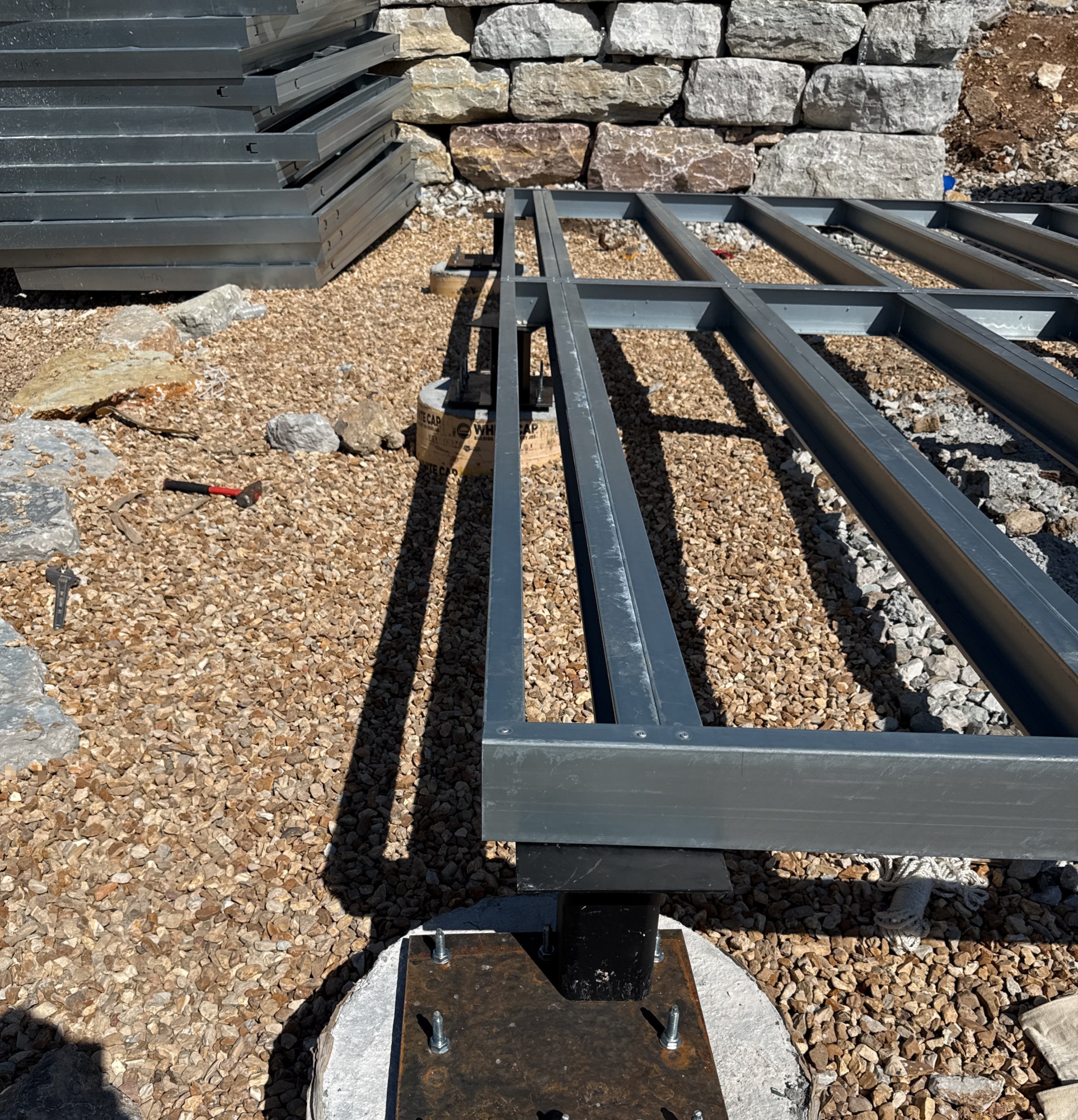 Steel floor beam landing on a levelled pier cap plate above a concrete pier, 4 May 2026