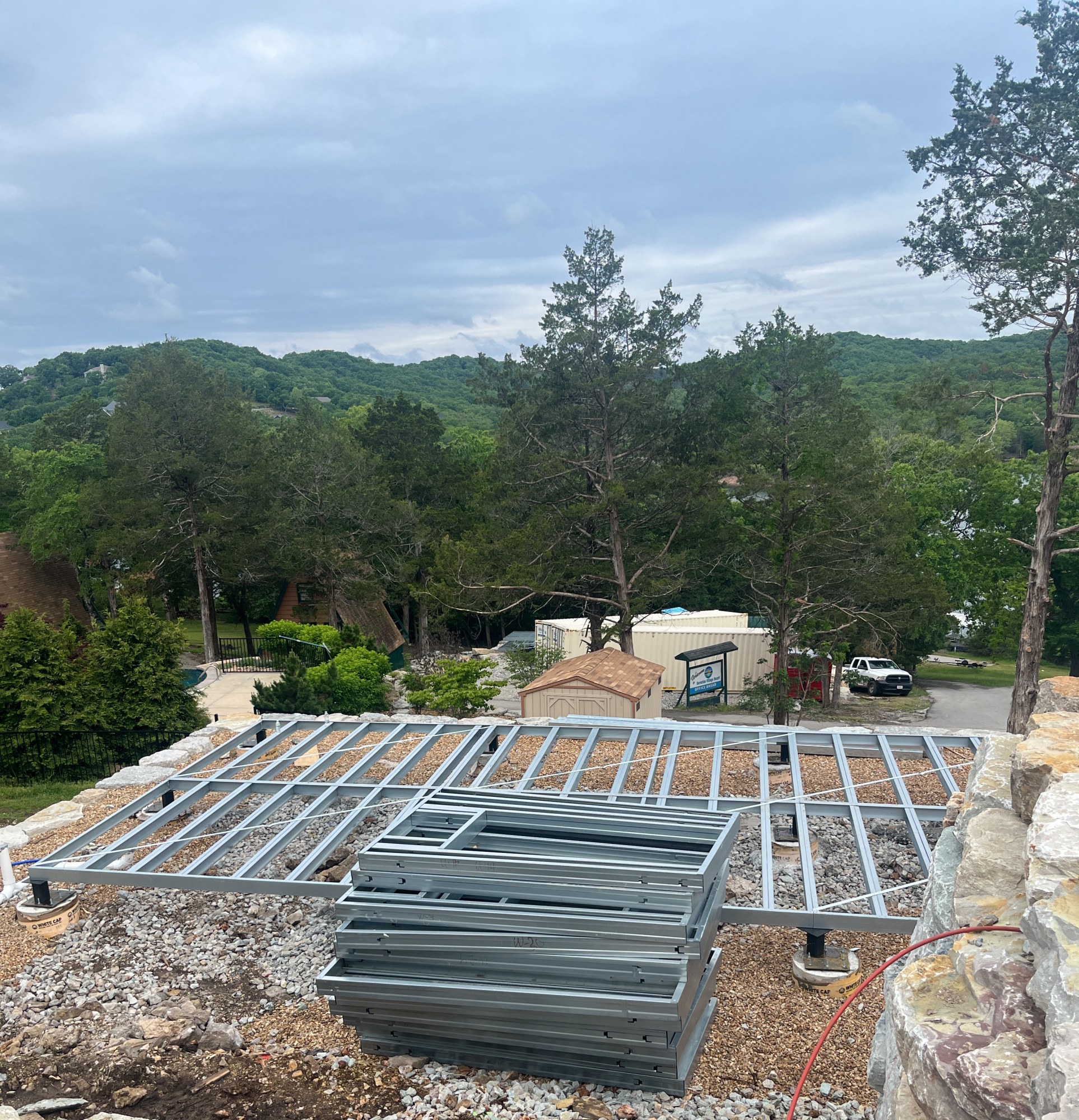 Completed steel floor platform seen from above with prefabricated wall panels stacked alongside, 6 May 2026